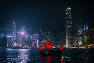 Hong Kong city skyline at night with boat on water in foreground