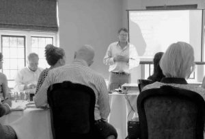 black and white photo of Ben Moreton Wright presenting to a group of people