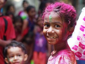 Photo of a smiling girl covered in coloured powder